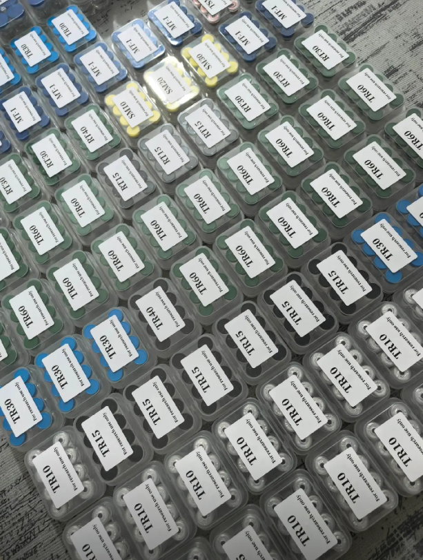 Rows of colour-coded labelled containers on a work surface